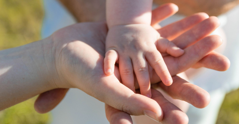 Parents holind a child's hand.