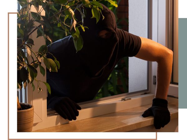 a man wearing a ski mask breaking into a home