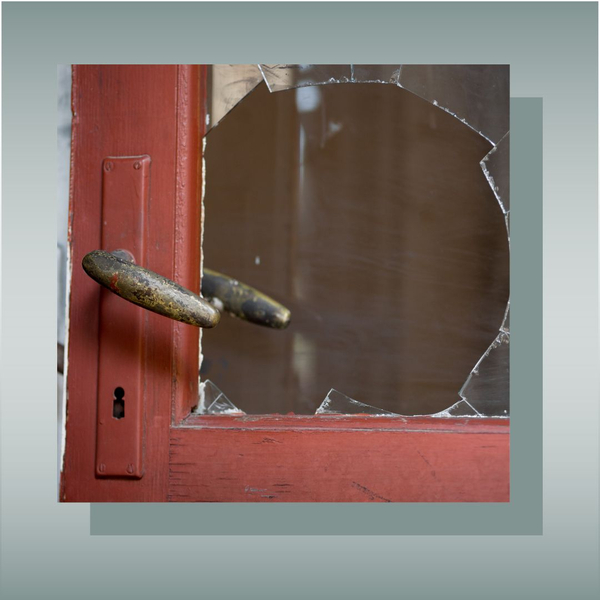 Broken glass door with a damaged lock, representing burglary