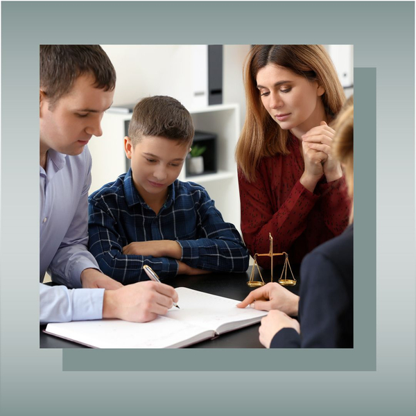 Parents and child signing legal documents with an attorney