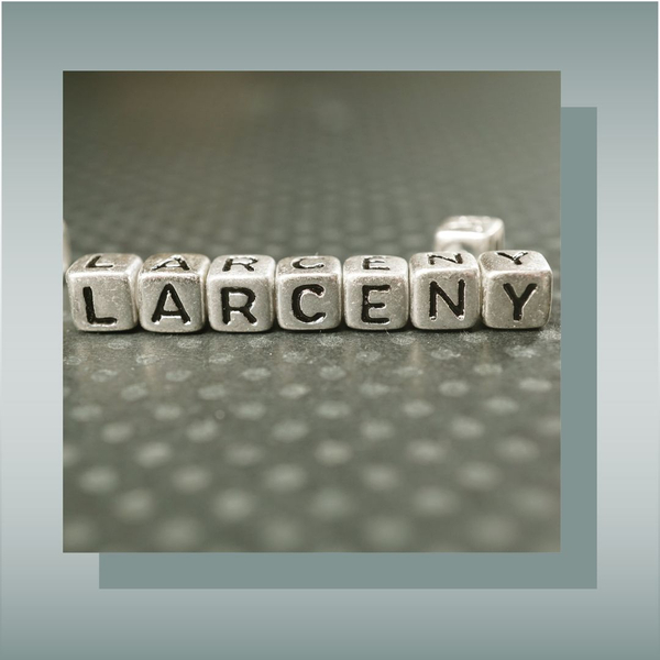 Larceny spelled out with letter blocks on a textured surface