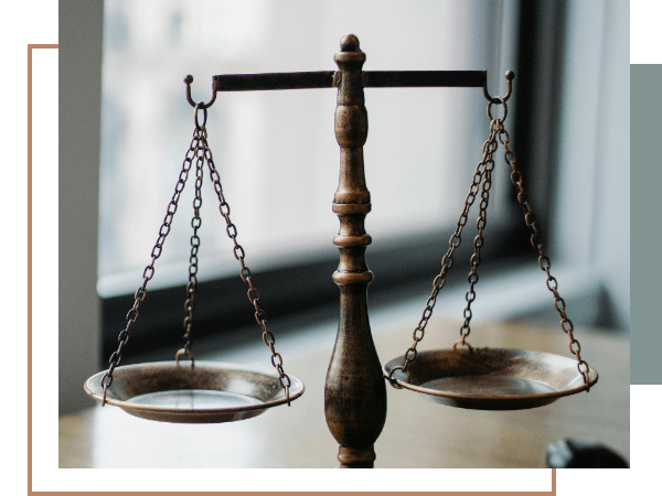 Brass scales of justice on a wooden desk representing legal representation for suspended license charges