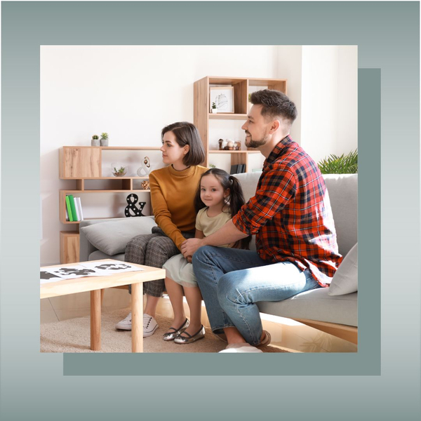 Family of three sitting together, appearing attentive and engaged