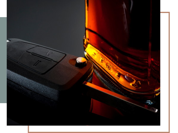 a bottle of alcohol with a car key