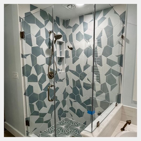 newly remodeled shower with intricate shower tiling