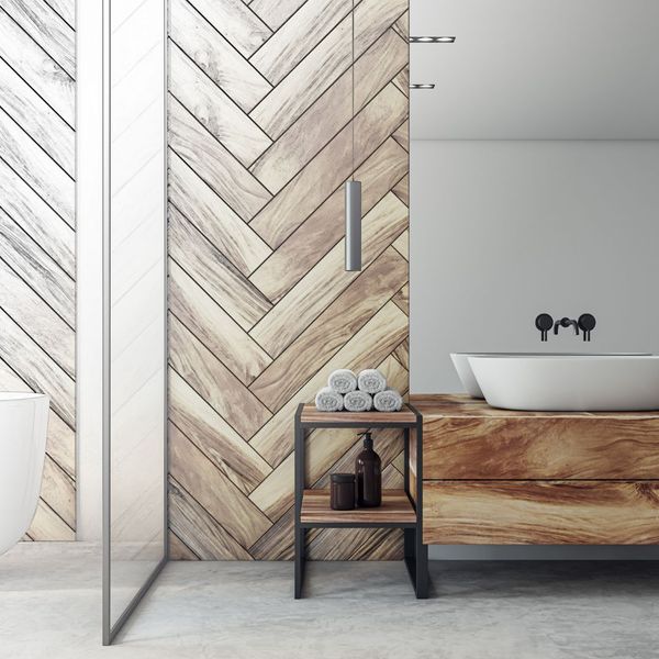 herringbone tile wall in bath, towels on teak rack