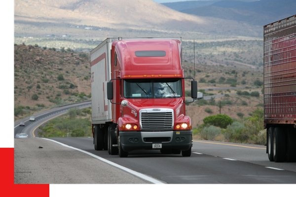 red semi truck driving down the road
