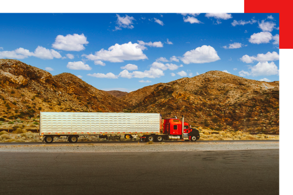 red and white semi truck parked on the side of the road