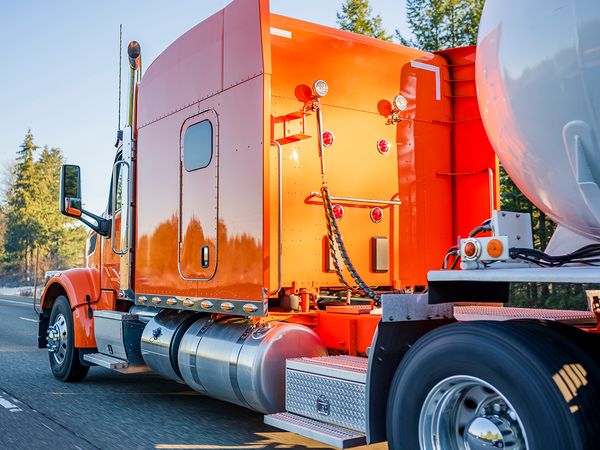 orange semi truck with  new tires