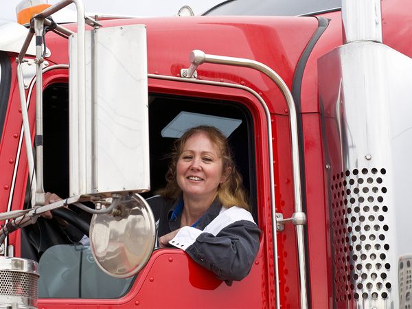 Woman truck driver looking out the drivers side window of truck