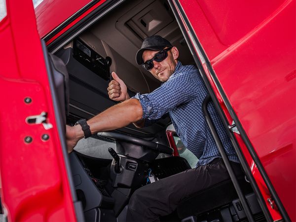 Driver giving thumbs up from cab of truck