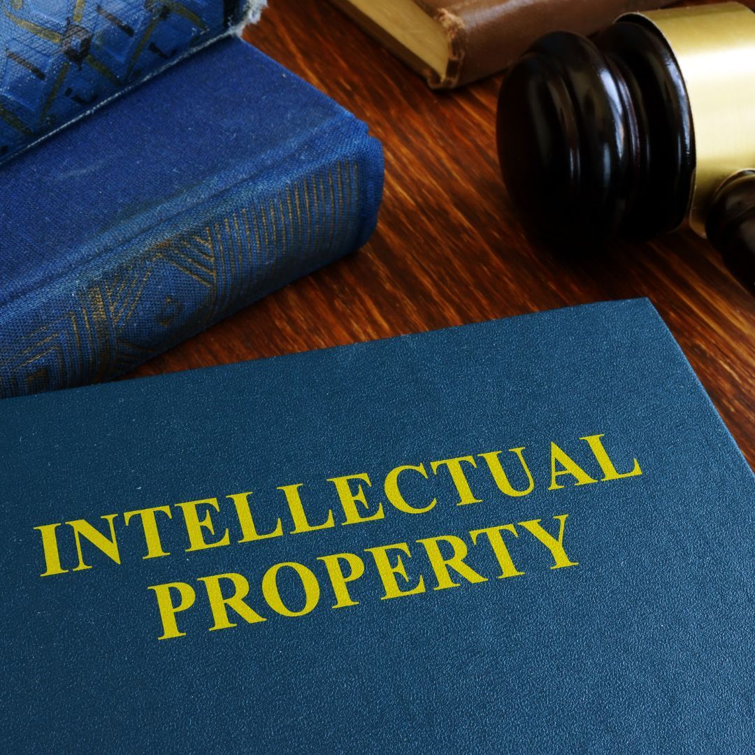 a book with "intellectual property" written on the front on a desk with a gavel