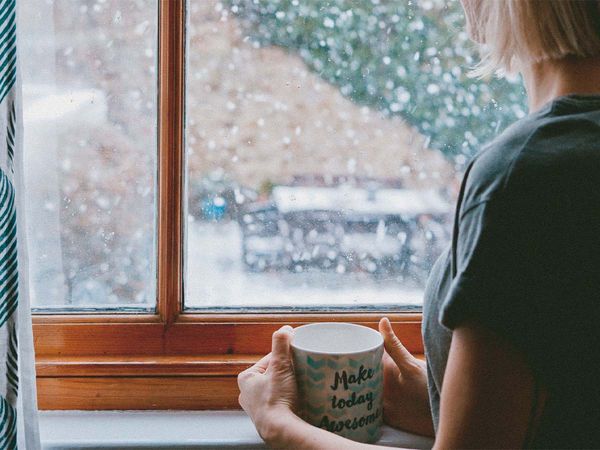 Looking out window with a mug