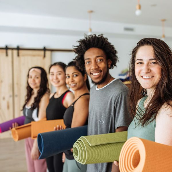 people standing in a line with yoga mats