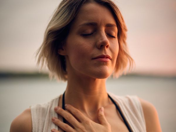 Woman meditating with her hand on her chest
