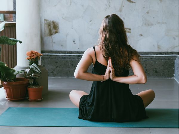 Woman doing yoga at home in comfortable clothes