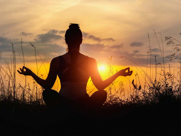 Woman doing yoga on the sunset. 