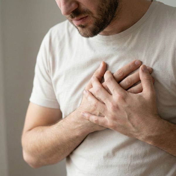 a person holding their chest in discomfort, conveying anxiety physically