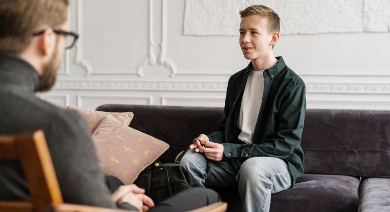 younger man speaking with counselor