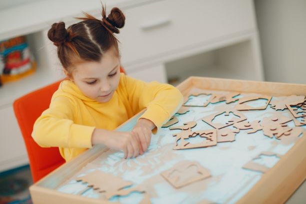 Little girl completing a puzzle