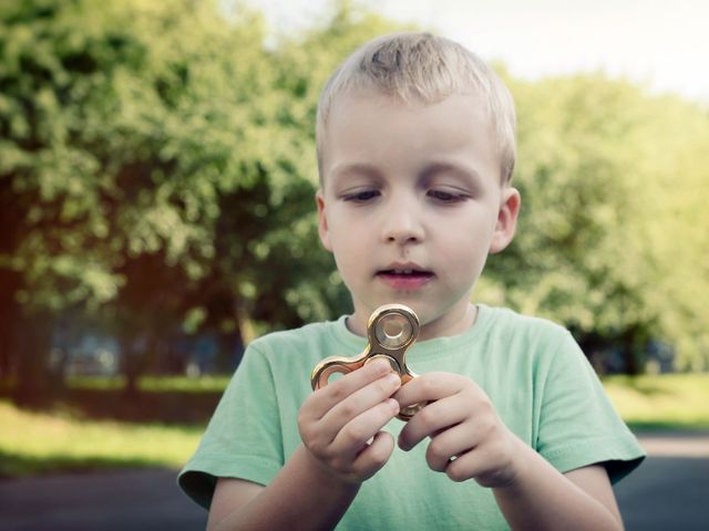 young boy playing with a fidget spinner