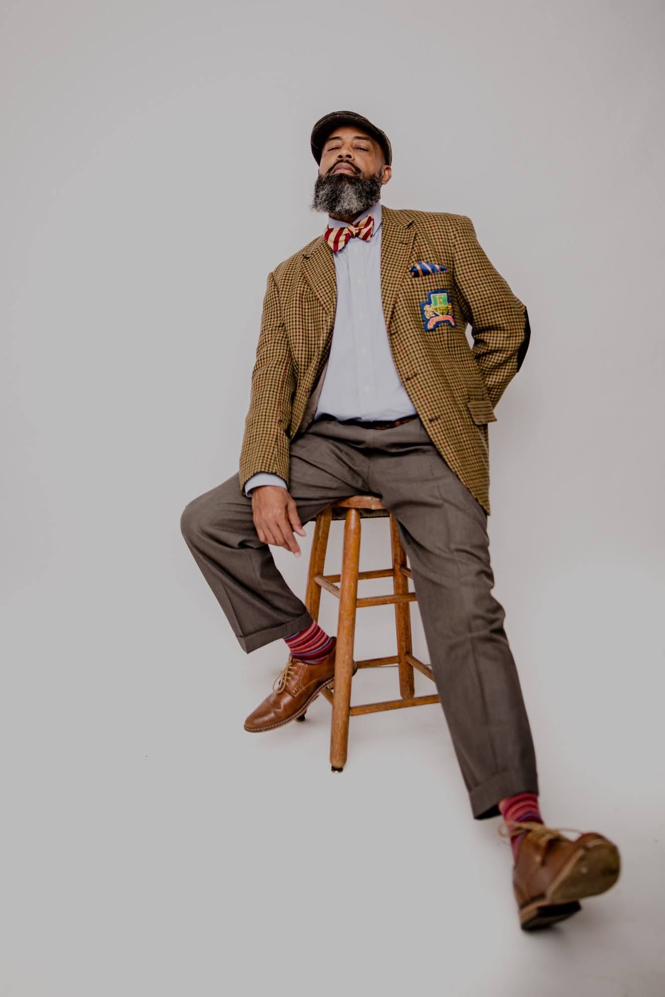 man in vintage clothes sitting on stool