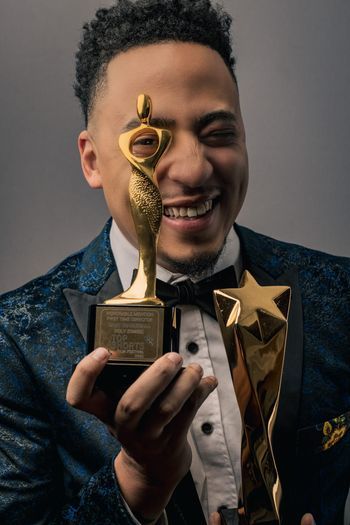 smiling man looking through a trophy