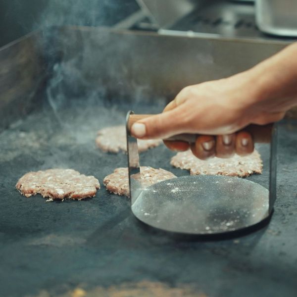 smash burger being prepared on griddle