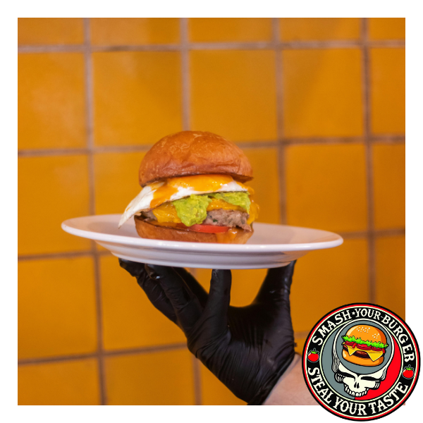 person holding a burger on a plate