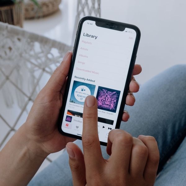 person using phone to create music playlist