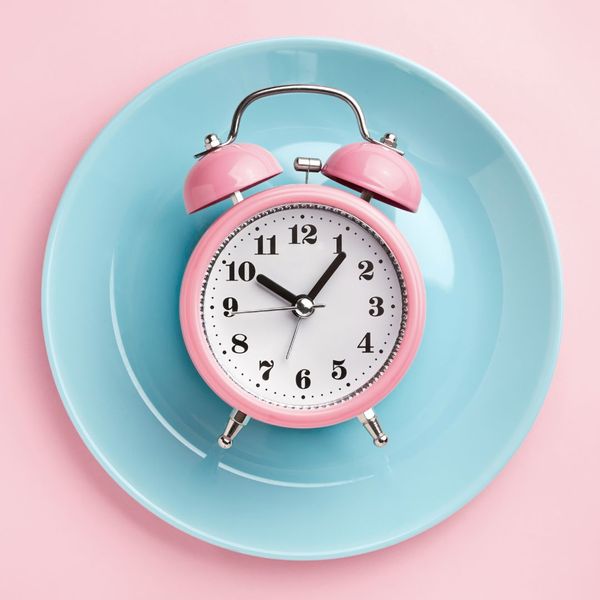 Pink clock on a blue plate. 
