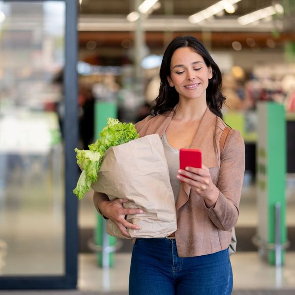 A happy woman leaving the grocery store