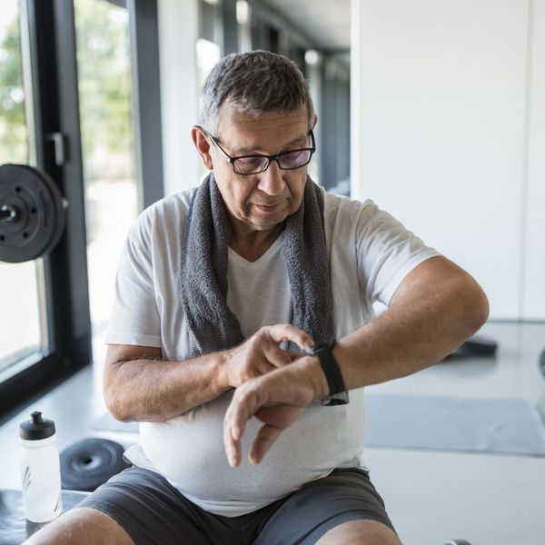 A senior man using his smartwatch to track his workout