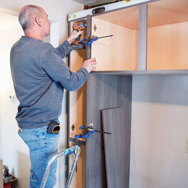 man installing cabinets