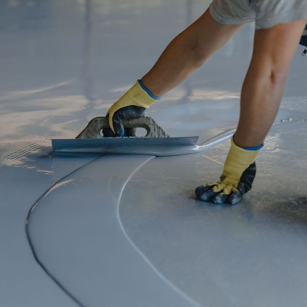 a person spreading epoxy on a floor