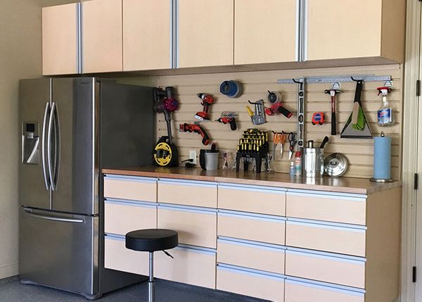 photo of an organized garage with slat wall installed above work bench