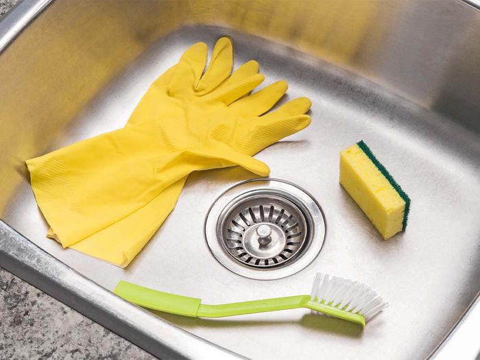 Brush and gloves in a sink