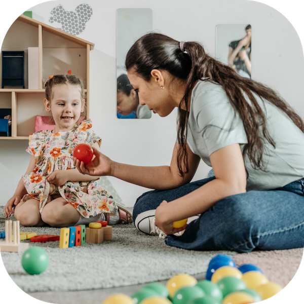 therpist handing child a ball