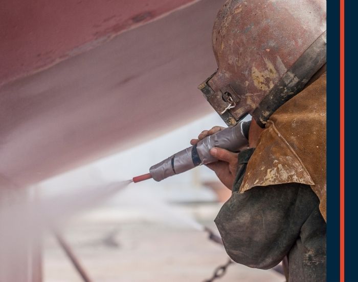 Worker sandblasting a project