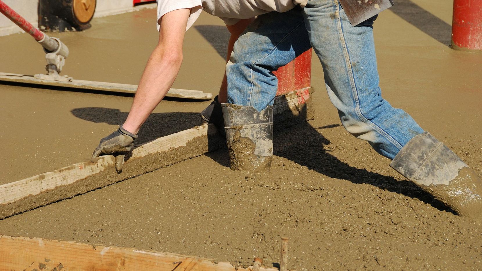 construction worker spreading wet concrete
