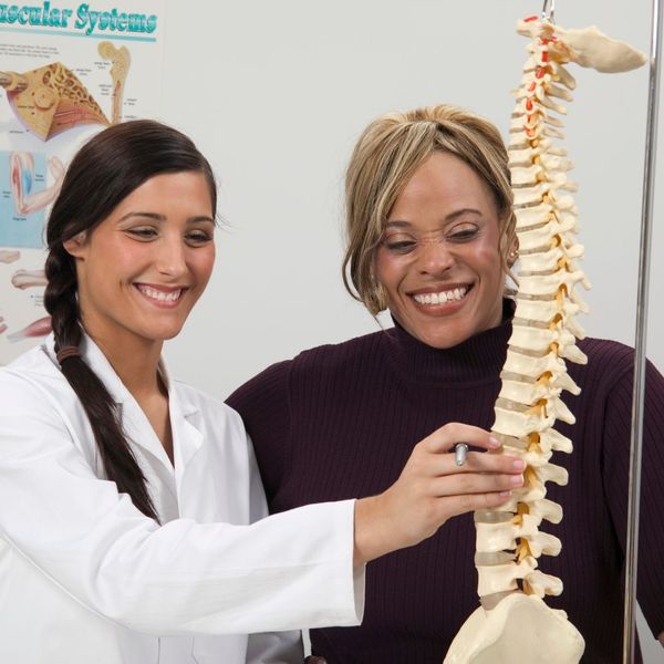 chiropractor and patient examining a spine model