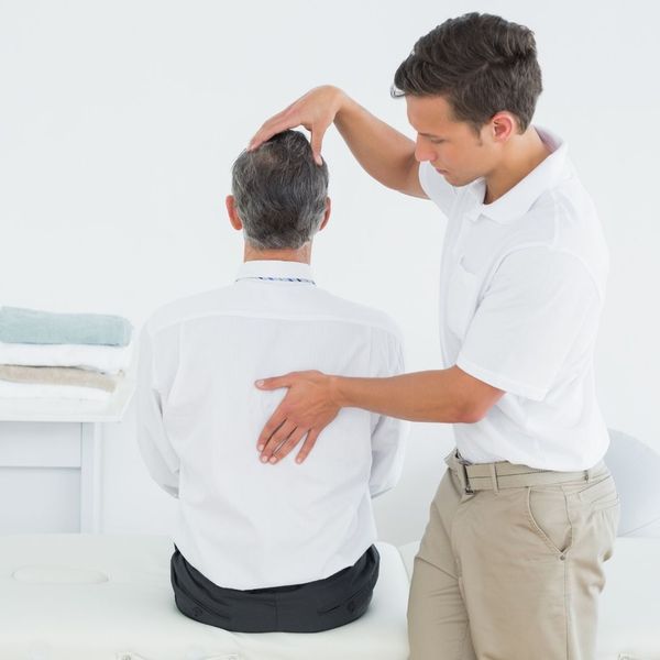 chiropractor adjusting man's back