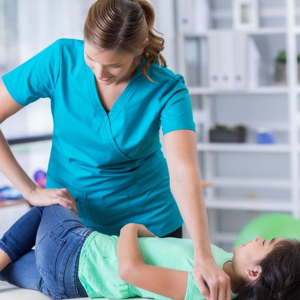 woman giving chiropractic care to a child
