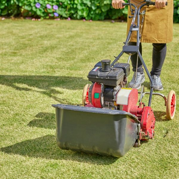 a person using a lawn mower on grass