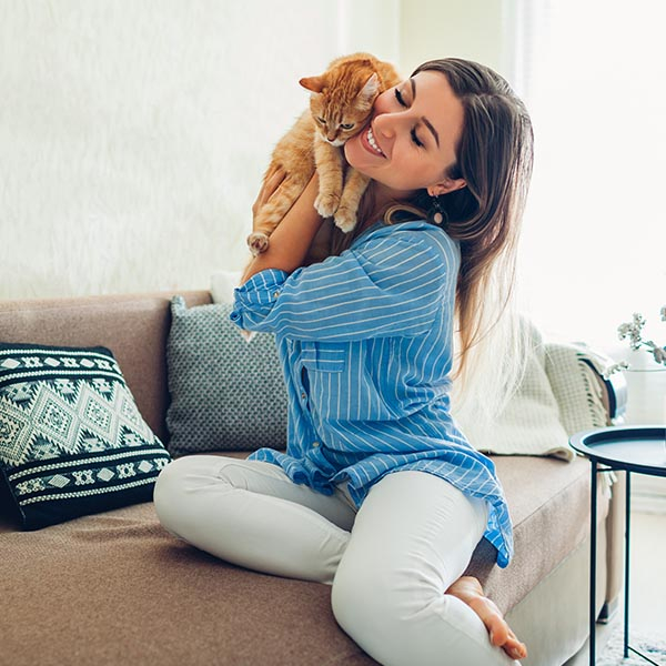 smiling woman holding pet cat