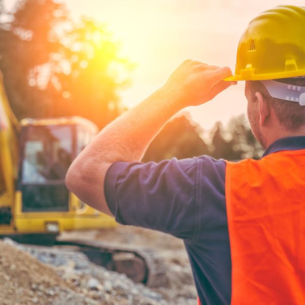 construction worker looking at excavator