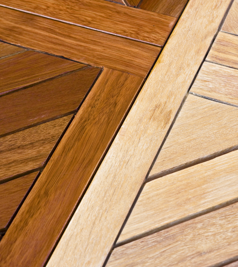 Wood flooring, half of which is stained a deep color, the other half is plain, light pine