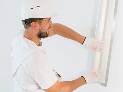 A contractor smoothing out a wall