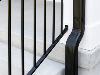 Black metal railings and gutter on a house's front porch