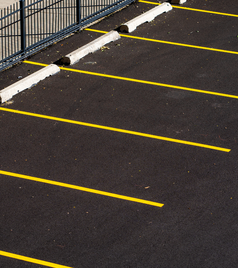 A parking lot with freshly painted yellow lines for parking spaces